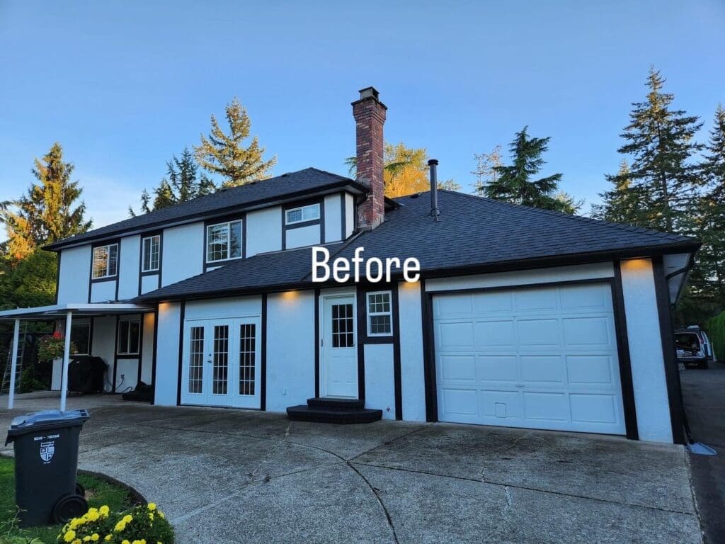 A two-story house with a black roof, white walls, and black trim. The driveway leads to a garage on the right side.