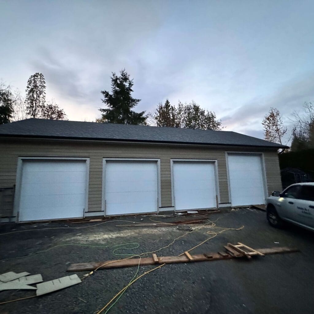 A garage with three white garage doors is shown in a suburban setting, with a cloudy sky and trees in the background.