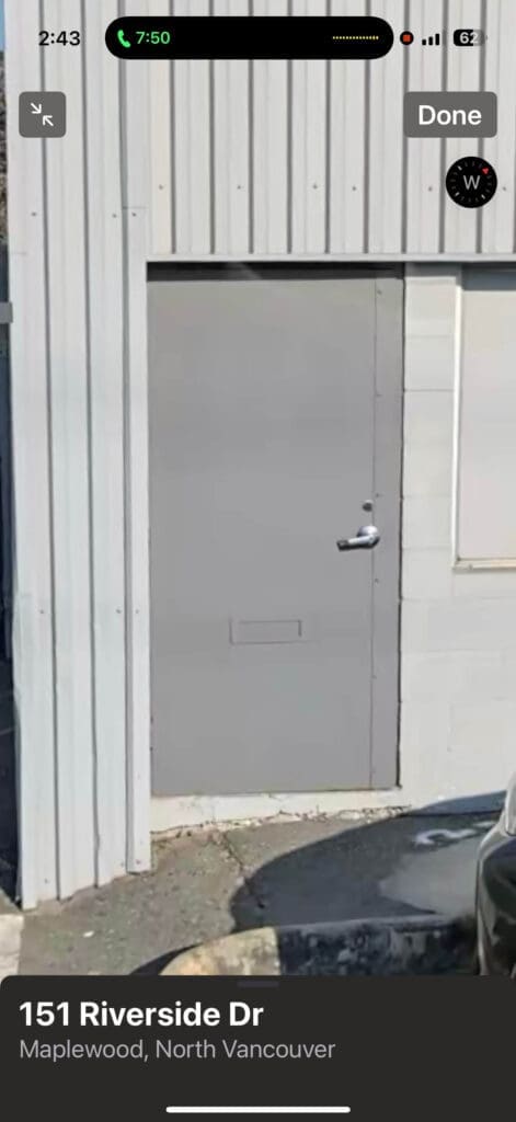 A gray door with a single doorknob, set against a metal wall.