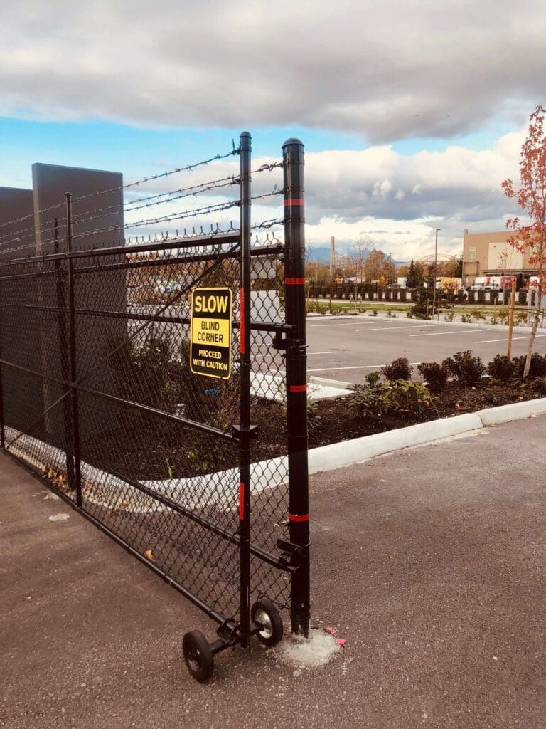 A chain-link fence gate with a warning sign